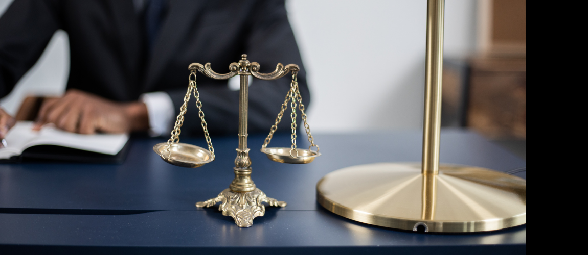 Man-Signing-Contract-Gold-Scales-and-lamp-in-front