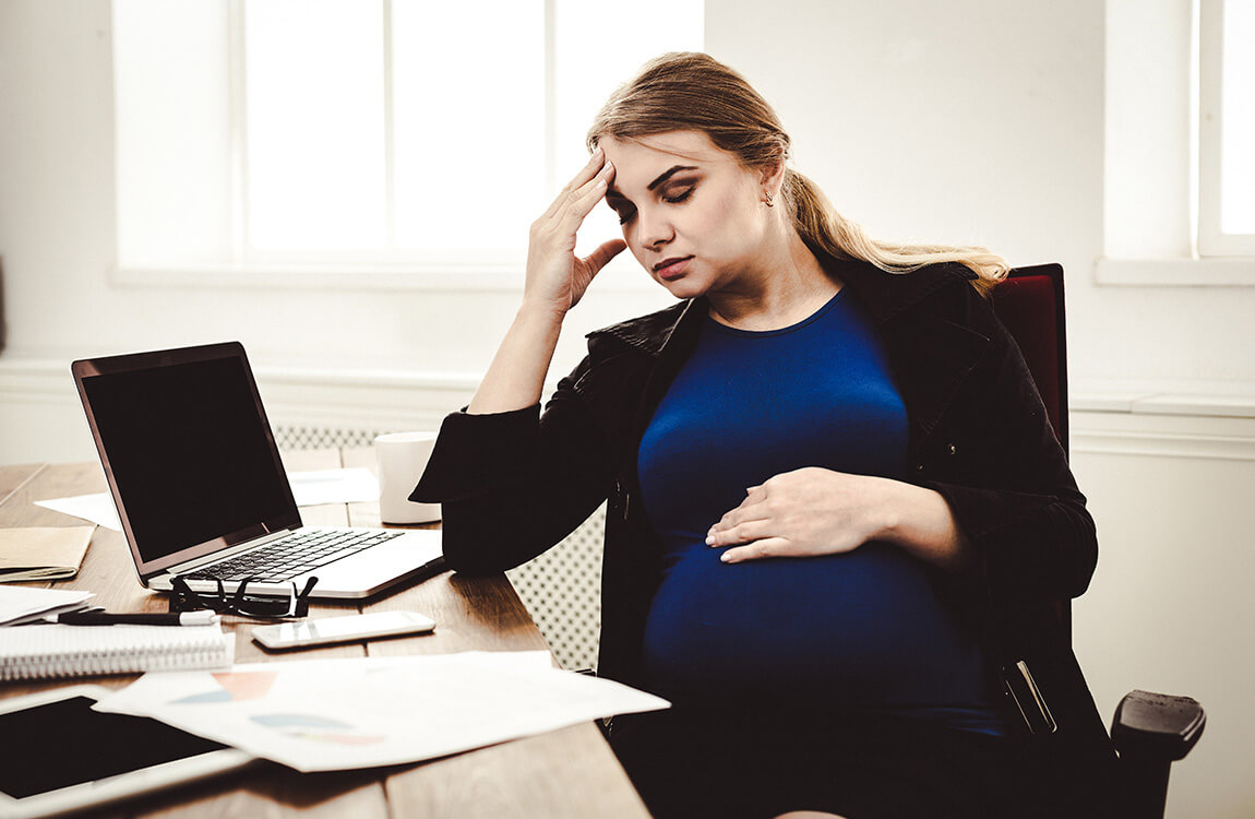 Tired-pregnant-businesswoman-at-office